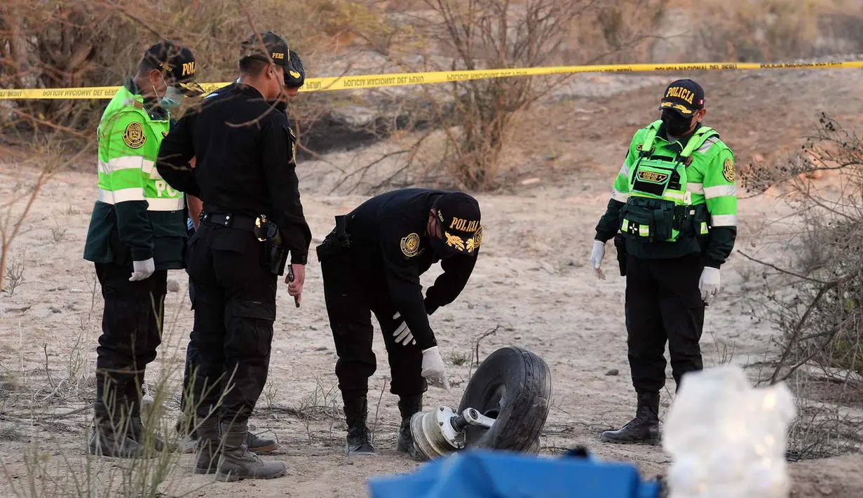 Polisi memeriksa puing-puing pesawat yang jatuh saat penerbangan wisata yang membawa turis di atas Garis Nazca di Peru, Sabtu, 1 Agustus 2026. (Foto AP/Genry Bautista)