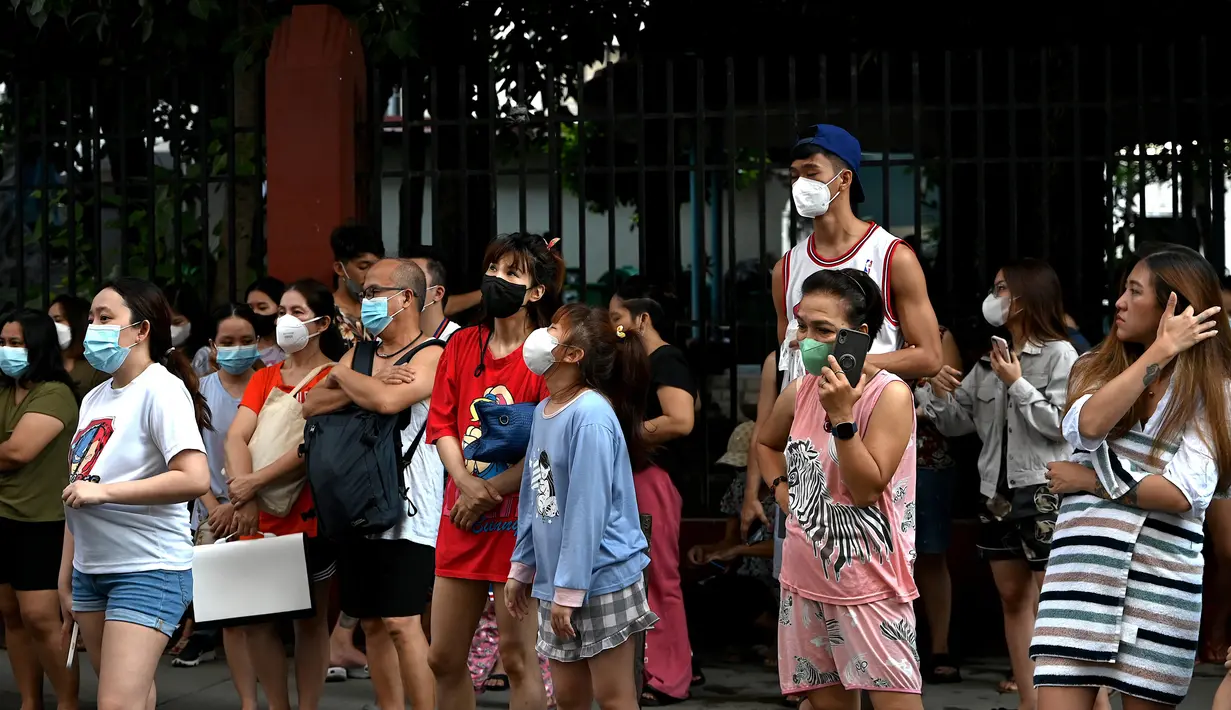 Warga menyelamatkan diri dengan keluar bangunan setelah gempa berkekuatan magnitudo 7,1 terasa di Manila, Filipina, Rabu (27/7/2022). (JAM STA ROSA/AFP)