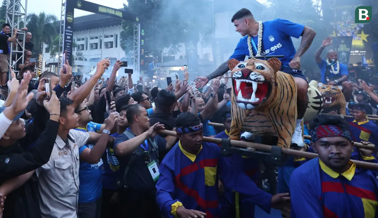 Striker Persib Bandung, Ciro Alves menyapa para fans dari atas Singa Depok setelah tiba bersama rombongan tim di Gedung Sate, Kota Bandung, Sabtu (1/6/2024) sore usai melakukan pawai juara BRI Liga 1 2023/2024. (Bola.com/M Iqbal Ichsan)