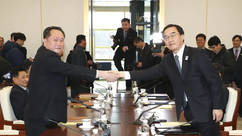 Menteri Unifikasi Korea Selatan Cho Myoung-gyon (kanan) berjabat tangan dengan Ketua Komite Reunifikasi Damai Korea Utara Ri Son Gwon dalam pertemuan di DMZ. (Korea Pool/Yonhap via AP)