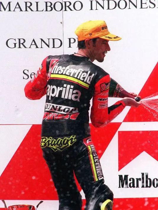 Pebalap 250cc asal Italia Max Biaggi merayakan tempat kedua dalam kategori 250cc pada Marlboro Indonesian Grand Prix di Sirkuit Sentul, 7 April 2996. Biaggi finish di belakang Tetsuya Harada. (JOHN MACDOUGALL/AFP)