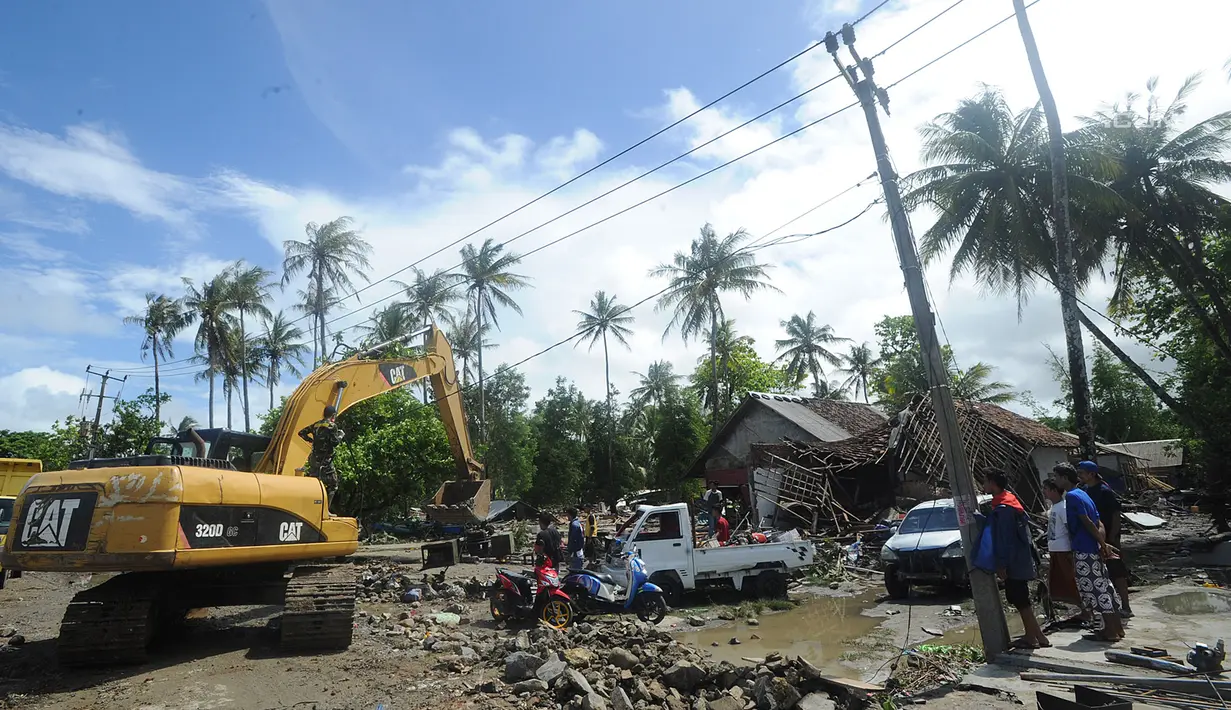 Alat berat melakukan proses evakuasi usai tsunami menerjang Kampung Sumur, Ujung Kulon, Banten, Selasa (24/12). Warga Kampung Sumur berlari menyelamatkan diri ke bukit saat tsunami menerjang. (Merdeka.com/Arie Basuki)