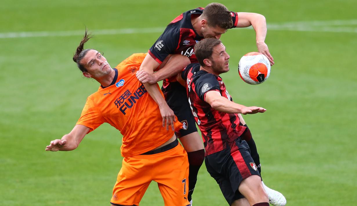 Striker Newcastle United, Andy Carroll, berebut bola dengan pemain Bournemouth pada laga lanjutan Premier League pekan ke-32 di Vitality Stadium, Kamis (2/7/2020) dini hari WIB. Newcastle menang 4-1 atas Bournemouth. (AFP/Michael Steele/pool)
