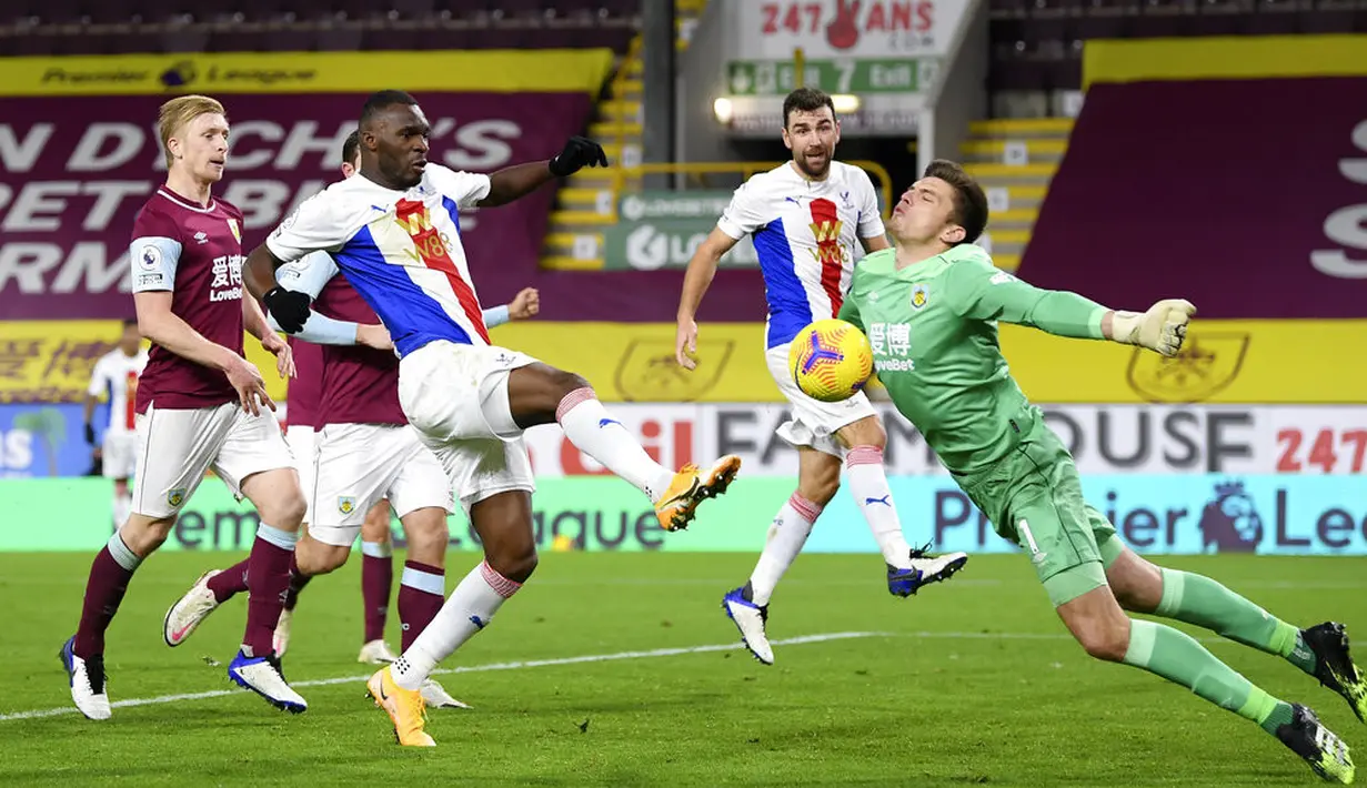 Kiper Burnley Nick Pope (kanan) melakukan penyelamatan di depan pemain Crystal Palace Christian Benteke pada pertandingan Liga Premier Inggris di Stadion Turf Moor, Burnley, Inggris, Senin (23/11/2020). Burnley menang dengan skor 1-0. (Michael Regan/Pool via AP)