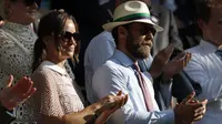 Pippa Middleton ditemani adiknya, James Middleton, menyaksikan hari ketiga kejuaraan tenis Grand Slam Wimbledon 2017 di London, Rabu (5/7). Pippa menyempurnakan gayanya tersebut dengan kacamata hitam yang terasa semakin glamor. (Adrian DENNIS / AFP)