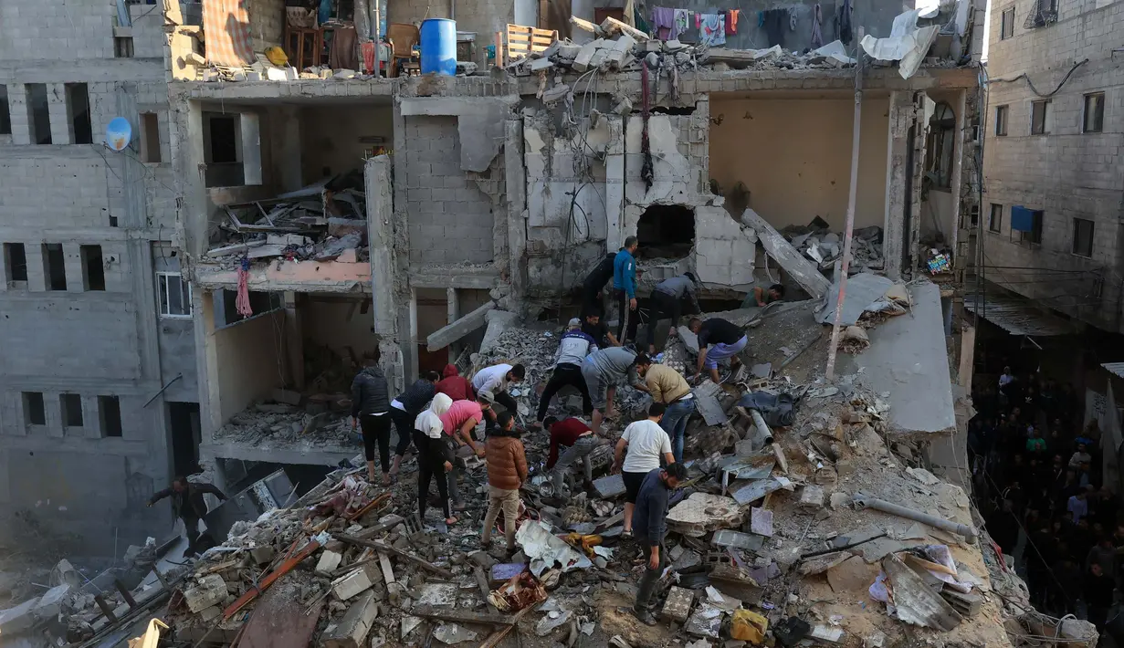 <p>Warga Palestina memeriksa kerusakan di sekitar bangunan tempat tinggal setelah serangan udara Israel di kamp pengungsi Rafah di Jalur Gaza Selatan pada 1 Desember 2023, (SAID KHATIB/AFP)</p>