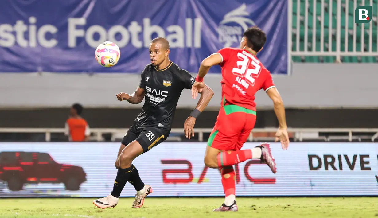 Pemain Dewa United, Alex Martins (kiri) dijaga ketat oleh pemain Persebaya Surabaya, Riswan Lauhin dalam pertandingan Dewa United melawan Persebaya Surabaya pada pekan ke-24 BRI Liga 1 di Stadion Pakansari, Kabupaten Bogor, Jumat (21/2/2025) malam WIB. (Bola.com/Abdul Aziz)