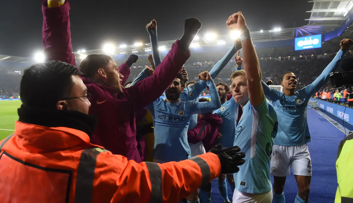 Para pemain Manchester City merayakan kemenangan bersama fans usai kalahkan Leicester City pada laga Piala Liga Inggris di King Power Stadium, Leicester, (19/12/2017). Manchester City menang lewati penalti  4-3. (AFP/Paul Ellis)