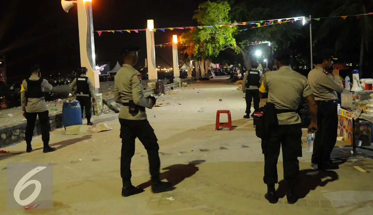 Petugas polisi berjaga di sekitar pantai Lagoon, Ancol, Jakarta Utara, Sabtu (31/12) malam. Benda diduga bom tersebut berhasil diamankan. Situasi pergantian tahun baru kembali kondusif. (Liputan6.com/Gempur M. Surya)