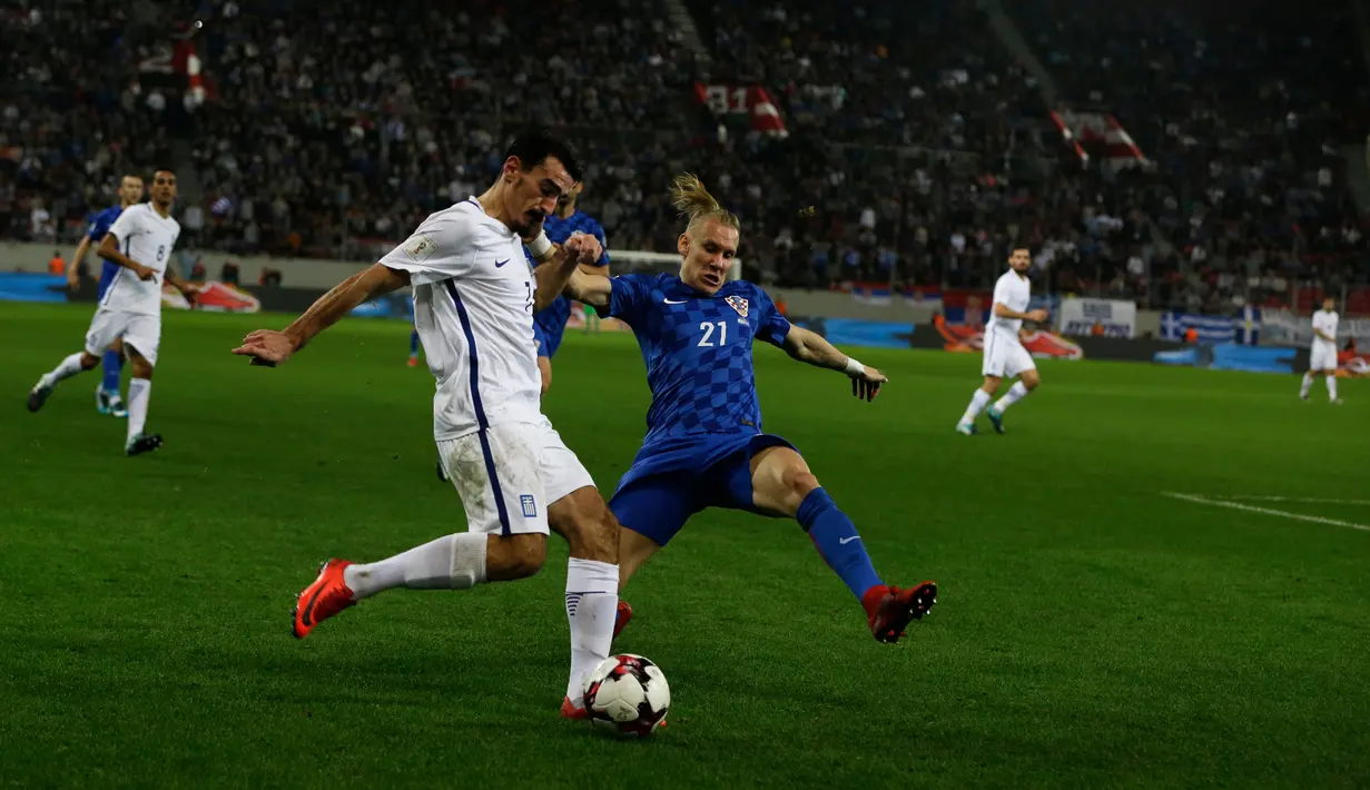 Pemain Yunani, Lazaros Christodoulopoulos berebut bola dengan pemain Kroasia, Domagoj Vida pada laga leg kedua play-off Piala Dunia 2018 di Stadion Karaiskakis, Senin (13/11). Kroasia menang dengan agregat 4-1 atas Yunani. (AP/Thanassis Stavrakis)
