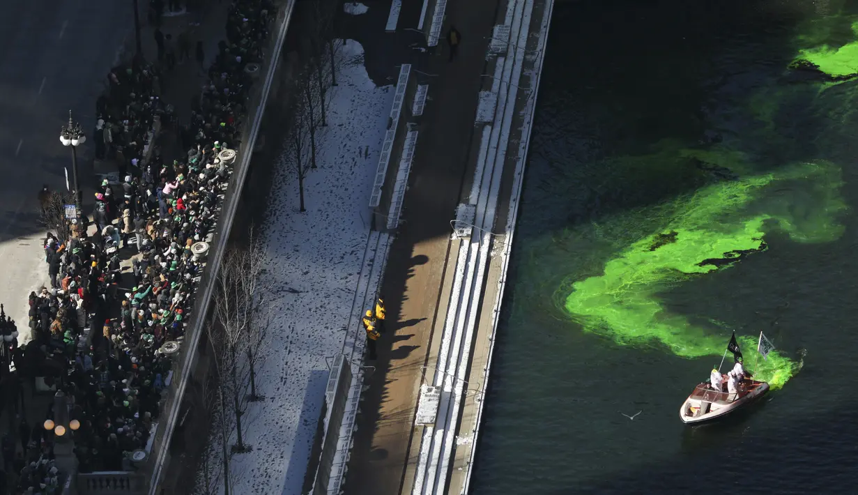 Orang-orang berdiri di sepanjang West Wacker Drive untuk menyaksikan pewarnaan Sungai Chicago untuk Hari St. Patrick yang akan datang, seperti yang terlihat dari ballroom penthouse lantai 39 di hotel Royal Sonesta, Chicago, Sabtu (12/3/2022). (John J. Kim/Chicago Tribune via AP)
