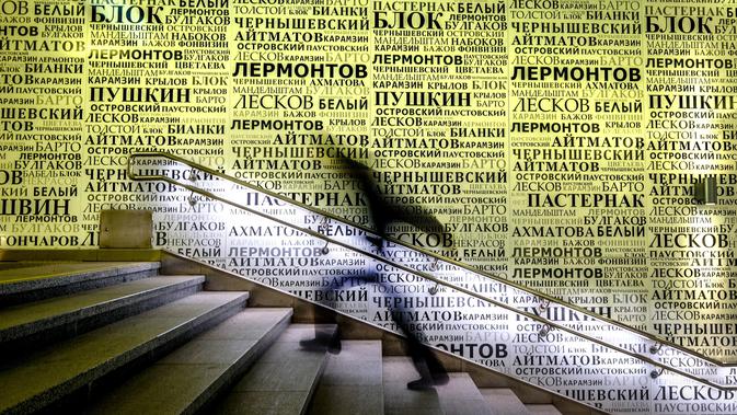 Komuter melewati dinding yang dihiasi dengan nama-nama penulis dan penyair Rusia di stasiun metro Rasskazovka, pada 10 November 2018. Metro Moskow adalah sistem kereta bawah tanah dengan arsitekstur yang indah. (Photo by Yuri KADOBNOV / AFP)