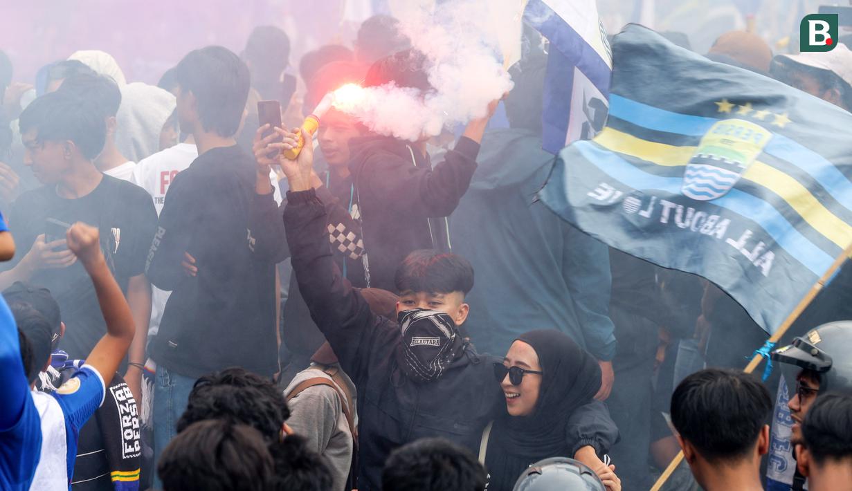 Dua orang Bobotoh berpesta saat merayakan pesta juara BRI Liga 1 di Gedung Sate, Minggu (25/5/2025). (Bola.com/M Iqbal Ichsan)