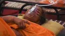 Seorang pasien bernafas dengan bantuan oksigen yang disediakan oleh Gurdwara, tempat ibadah untuk Sikh, di bawah tenda yang dipasang di sepanjang pinggir jalan di Ghaziabad, Selasa (4/5/2021). Total kasus Corona di India sudah menembus angka 20 juta pada Selasa, 4 April 2021. (Tauseef MUSTAFA/AFP)