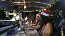 Pelayan melayani pengunjung restoran gantung dengan dekorasi kereta salju santa claus di Kuala Lumpur, Malaysia, Rabu (5/12). Pengunjung ditawarkan sensasi bepergian dengan kereta salju santa claus lengkap dengan rusa. (MOHD RASFAN/AFP)