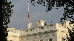 Pekerja berjalan di atap Gedung Putih di Washington, Kamis (26/8/2021). Semua gedung federal dan fasilitas militer milik AS akan mengibarkan bendera AS setengah tiang untuk menghormati anggota marinir AS dan lainnya yang tewas dalam serangan bom di Kabul, Afghanistan. (AP Photo/Susan Walsh)