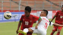 Pemain belakang timnas U-16 Vietnam, Do Huu Minh Quang (tengah) berusaha membuang bola dari Kevin Sahael (Indonesia - kiri) saat berlaga di Stadion GBK Jakarta, (3/12/2014). Indonesia unggul 3-2 atas Vietnam. (Liputan6.com/Helmi Fithriansyah)