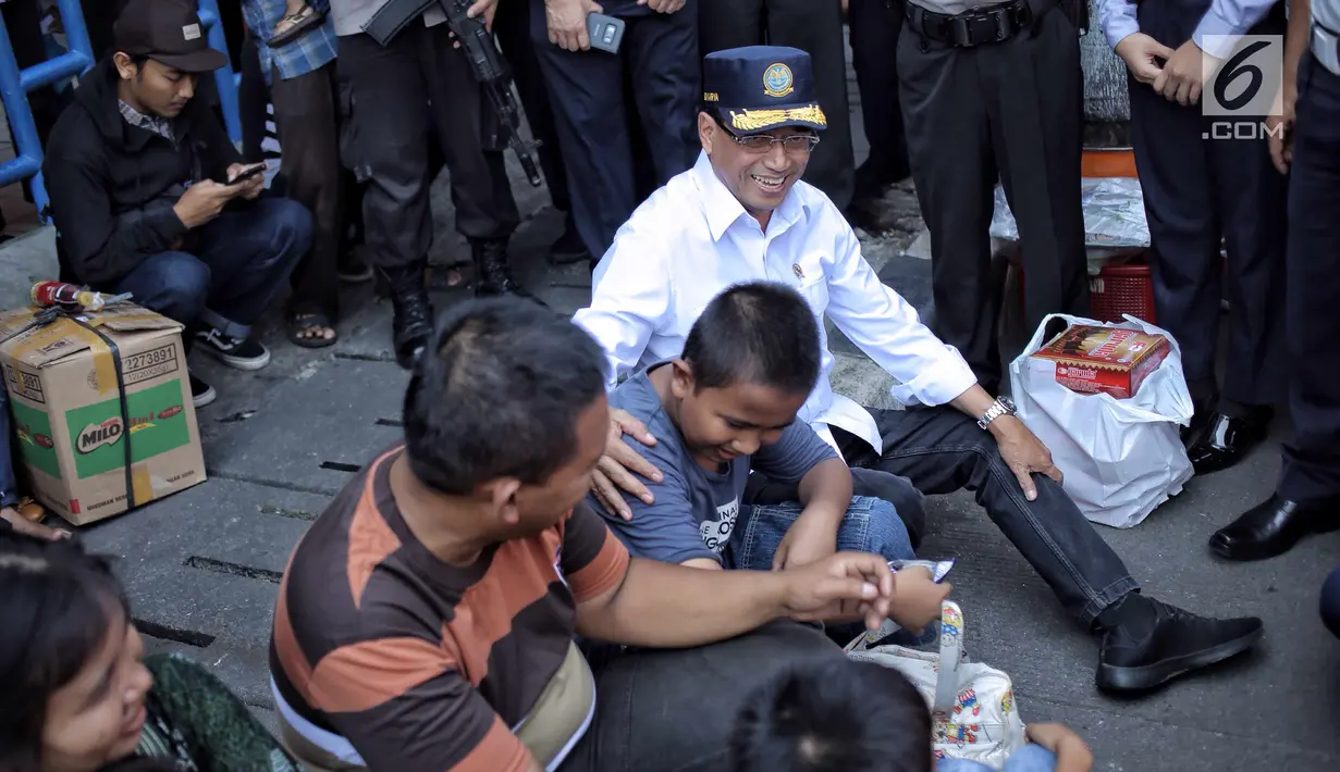 Menhub Budi Karya Sumadi (kanan) berbincang dengan penumpang saat meninjau kesiapan arus balik Lebaran di Terminal Kampung Rambutan, Jakarta, Selasa (19/6). (Liputan6.com/Faizal Fanani)