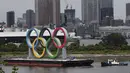 Sebuah perahu menarik cincin Olimpiade raksasa saat dipindahkan dari area tepi laut di Taman Laut Odaiba setelah Olimpiade Musim Panas 2020 berakhir pada 8 Agustus di Tokyo, Rabu (11/8/2021). Setelah ini, Kota Paris akan menjadi tuan rumah olimpiade pada 2024 mendatang. (Kim Kyung-Hoon/Pool via AP)