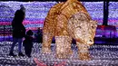 Seorang wanita bersama anaknya bermain diantara cahaya lampu yang memenuhi sebuah taman di Minsk, Belarus (5/2). Setelah matahari terbenam empat puluh pameran seni instalasi lampu menghiasi seluruh taman di Belarus. (AP Photo/Sergei Grits)
