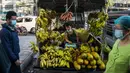 Seorang pria menjual pisang dari truk di sebuah pasar sehari setelah militer Myanmar merebut kekuasaan, Yangon, Myanmar, Selasa (2/2/2021). Militer Myanmar menahan pemimpin yang terpilih secara demokratis Aung San Suu Kyi dan memberlakukan keadaan darurat satu tahun. (STR/AFP)