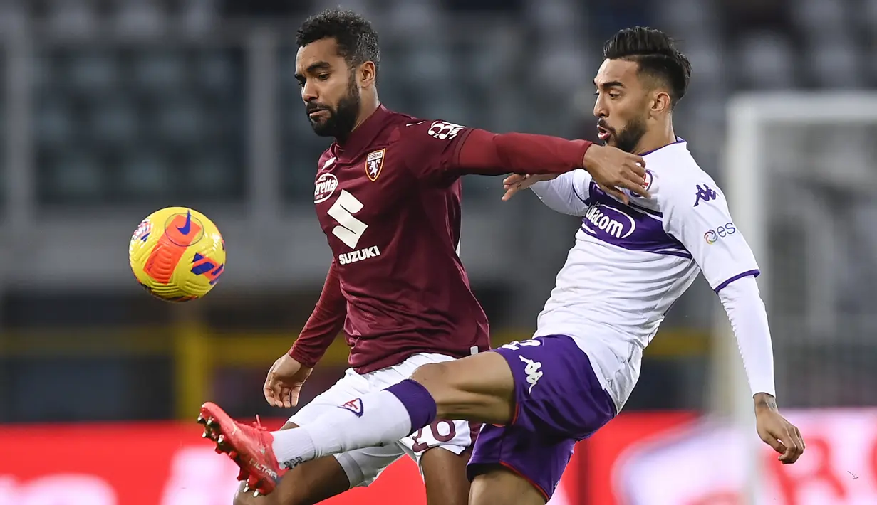 Bek Torino, Koffi Djidji berebut bola dengan pemain Fiorentina, Nicolas Gonzalez selama pertandingan lanjutan Liga Serie A Italia di stadion Olimpiade di Turin, Italia, Selasa (11/1/2022). Torino menang telak atas Fiorentina 4-0. (Fabio Ferrari/LaPresse via AP)