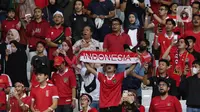 Pendukung timnas Indonesia membentang syal saat menyaksikan laga kualifikasi Grup A Piala AFF 2022 antara Indonesia melawan Kamboja di di Stadion Utama Gelora Bung Karno, Jakarta, Jumat (23/12/2022). Indonesia unggul 2-1 atas Kamboja lewat gol yang dicetak Egy Maulana Vikry dan Witan Sulaeman. (Liputan6.com/Helmi Fithriansyah)