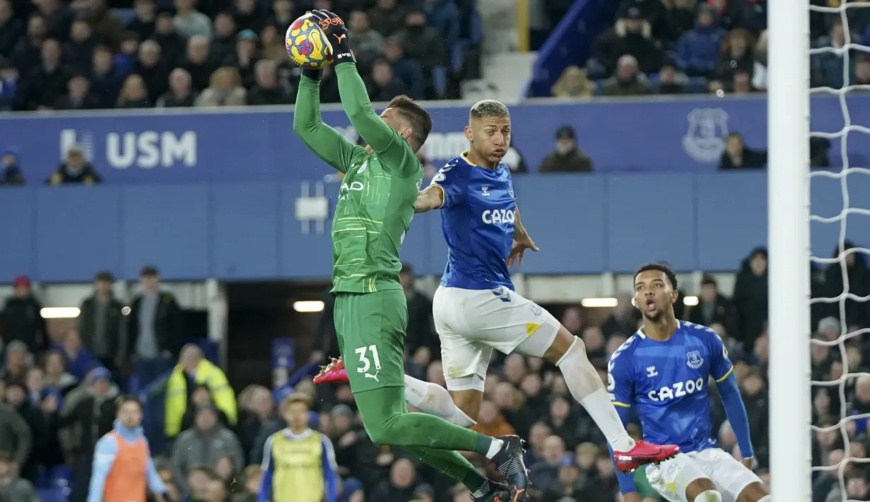 Penjaga gawang Manchester City, Ederson (kiri) melakukan penyelamatan di depan pemain Everton Richarlison selama pertandingan lanjutan Liga Inggris di Goodison Park di Liverpool, Inggris, Minggu (27/2/2022). Man City menang tipis atas Everton 1-0. (AP Photo/Jon Super)
