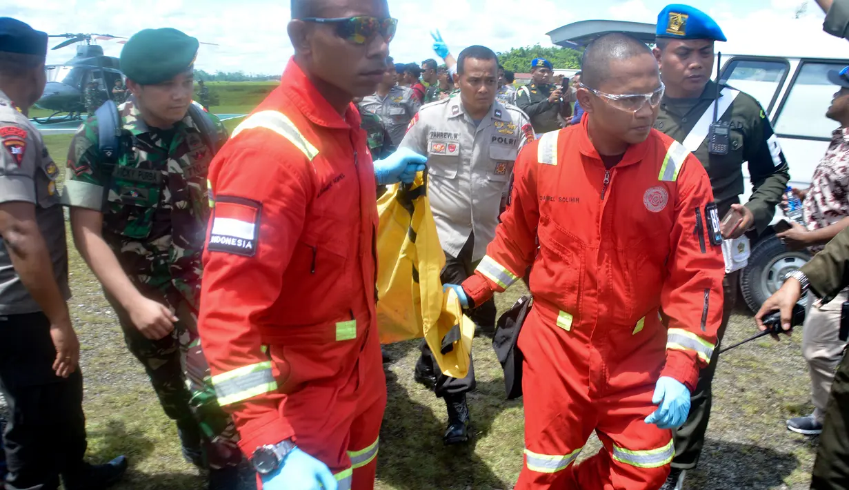 Tentara dan polisi membawa kantong jenazah korban serangan Kelompok Kriminal Bersenjata (KKB), Timika, Papua, Kamis (6/12). Korban meninggal merupakan pekerja proyek Trans Papua. (JOSEPH SITUMORANG/AFP)