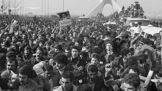 Iring-iringan pemimpin spiritual Iran, Ayatollah Khomeini berada di antara kerumunan pendukungnya dekat Bandara di Teheran, Iran. 1 Februari 1979. Rezim kerajaan Iran di bawah Shah runtuh pada 11 Februari 1979. (AP Photo/TA, File)