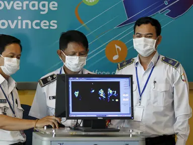 Petugas kesehatan memantau penumpang melalui mesin pemindai suhu tubuh di Bandara Internasional Phnom Penh, Kamboja, Selasa (23/6/2015). Pemerintah Kamboja meningkatkan pemeriksaan untuk mencegah penyebaran MERS. (REUTERS/Samrang Pring)