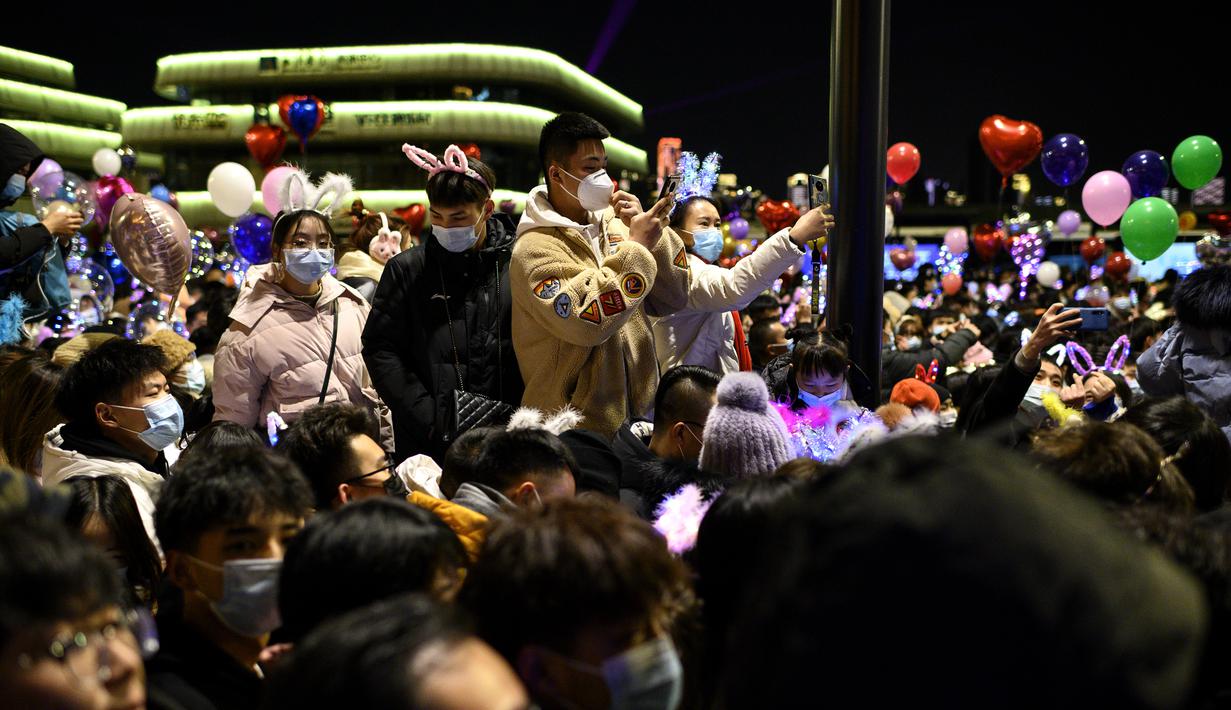 Orang-orang  selama hitung mundur Tahun Baru di Wuhan di provinsi Hubei,  China (1/1/2021). Setahun yang lalu hari ini, wabah Covid-19 dilaporkan di kota provinsi Hubei, yang kemudian menyebar ke seluruh dunia dan menewaskan lebih dari 1,8 juta orang. (AFP/Noel Celis)