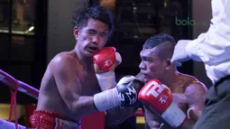 Jansen Marapu (kanan) melepaskan pukulan ke wajah Phuttiphong Rakoon pada kelas Lightweight Mahkota Boxing Super Series di Cilandak Town Square, Jakarta (10/3/2018). Jansen menang TKO ronde ke sembilan. (Bola.com/Nick Hanoatubun)