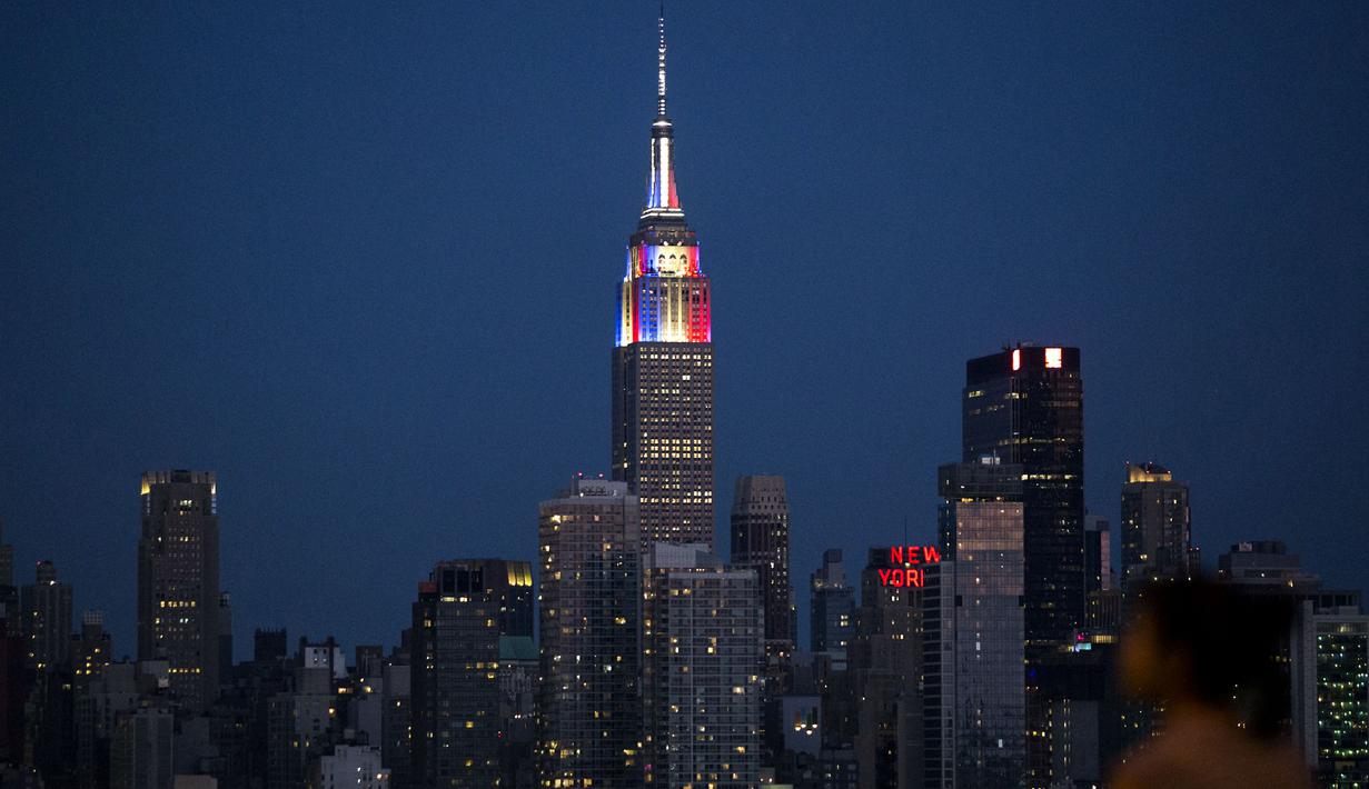 Gedung pencakar langit Empire State di New York memancarkan lampu warna bendera juara Piala Dunia 2018, Prancis, Minggu (15/7). Sebelumnya, pucak gedung terkenal di Amerika Serikat itu selalu menyalakan warna putih. (AFP PHOTO / KENA BETANCUR)