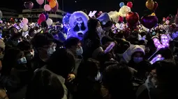 Orang-orang menghadiri  hitung mundur di Wuhan, provinsi Hubei tengah China, pada 31 Desember 2020, meskipun ada pembatasan Covid-19 dan kembang api Tahun Baru dibatalkan. (AFP/Noel Celis)