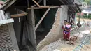 Warga berjalan melewati tembok yang roboh setelah gempa mengguncang Mandalawangi, Pandeglang, Banten, Sabtu (3/8/2019). Getaran akibat gempa Banten terasa ke kota-kota lain di Sumatera bagian selatan hingga Jawa bagian barat. (merdeka.com/Arie Basuki)