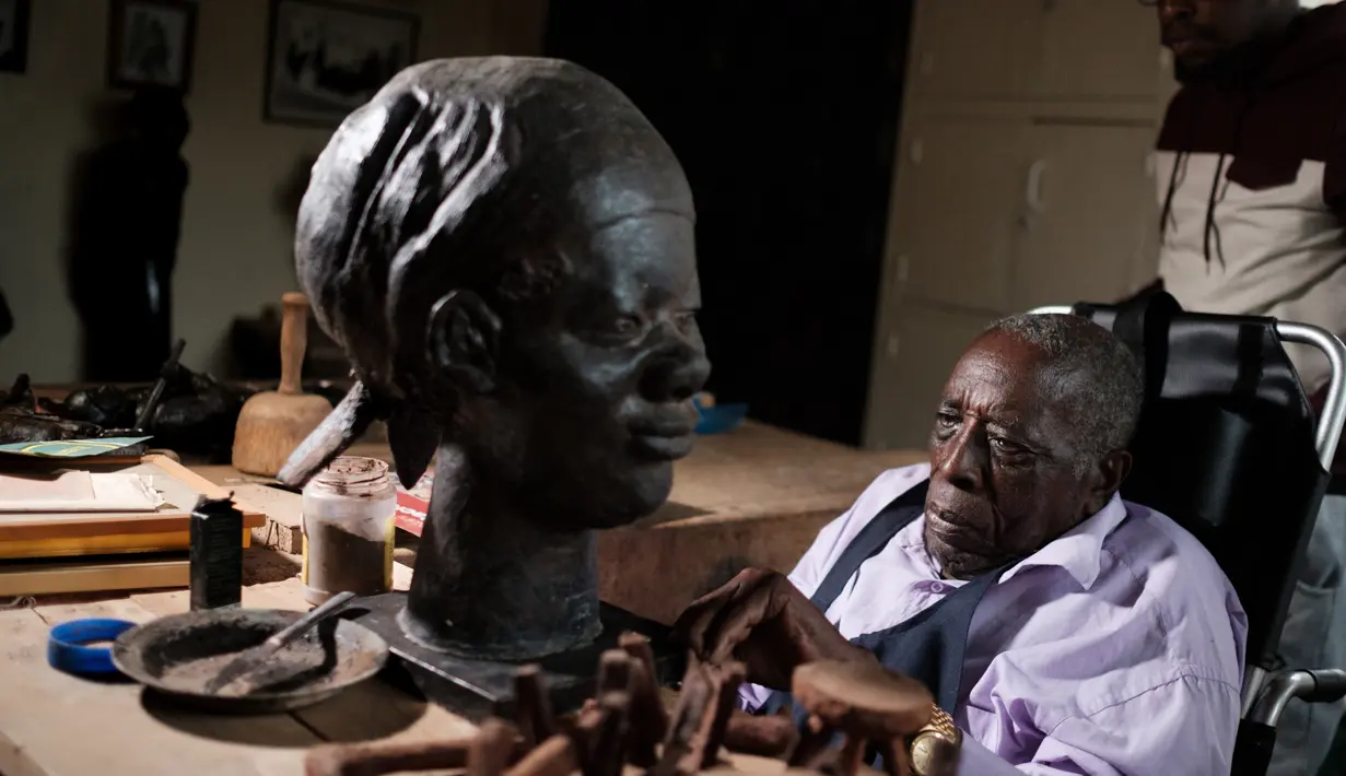 Edward Njenga bekerja memperbaiki patung karyanya yang berjuluk 'Women's Guild Member (2008)' di bengkelnya, Nairobi, Kenya, Senin (12/3). Njenga adalah salah satu pematung terkemuka asal Afrika Timur.  (AFP PHOTO/Yasuyoshi CHIBA)