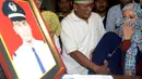 Istri (kanan) dan anak menyambut kedatangan jenazah Yudhistira Febbi Arianto, co pilot pesawat Aviastar di masjid dekat Bandara Ngurah rai, Bali, Kamis (8/10). Pesawat Aviastar jatuh dan menewaskan 3 kru dan 7 penumpang. (AFP PHOTO/SONNY TUMBELAKA)