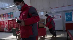 Kurir sibuk memilah paket di pusat distribusi di Beijing, China, Selasa (18/2/2020). E-commerce adalah salah satu dari sedikit industri yang berkembang setelah penutupan pabrik, restoran, bioskop, kantor, dan toko terkait wabah virus corona atau COVID-19. (AP Photo/Ng Han Guan)