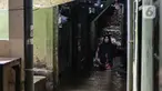 Warga melintas di kawasan pemukiman padat penduduk Kebon Pala, Kampung Melayu, Jakarta, Jumat (1/12/2023). (Liputan6.com/Faizal Fanani)