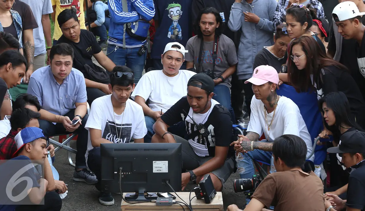 Young Lex bersama tim yang terlibat dalam pembuatan video klip Slow melihat hasil rekaman di kawasan Pancoran, Jakarta, Senin (3/10). Young Lex menggandeng Gamaliel 'GAC' dalam lagu bertajuk Slow tersebut. (Liputan6.com/Herman Zakharia)