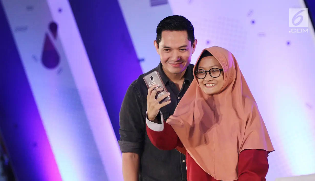 Seoang peserta berswafoto dengan artis peran Dude Harlino saat Emtek Goes To Campus (EGTC) 2018 di Universitas Negeri Semarang, Kamis (18/7). Dude Herlino selaku enterpreneur pengalaman dan rahasia suksesnya di EGTC. (Liputan6.com/Herman Zakharia)