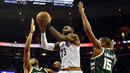 Pemain Cleveland Cavaliers, LeBron James (tengah)  melewati hadangan dua pemain  Milwaukee Bucks pada laga NBA di Quicken Loans Arena, Cleveland, (21/12/2016). Cavaliers menang 113-102. (Reuters/Ken Blaze-USA TODAY Sports)