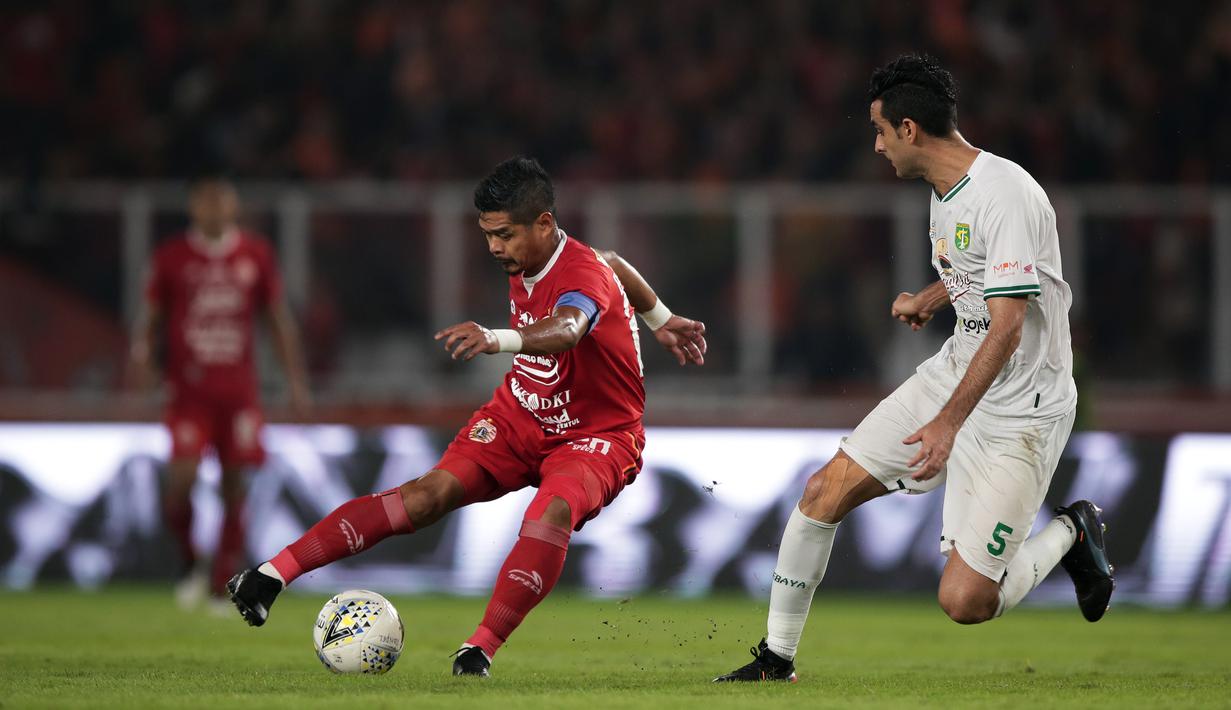 Striker Persija Jakarta, Bambang Pamungkas, berebut bola dengan pemain Persebaya pada laga Shopee Liga 1 di SUGBK, Jakarta, Selasa (17/12). Persebaya menang 2-1 atas Persija. (Bola.com/Yoppy Renato)