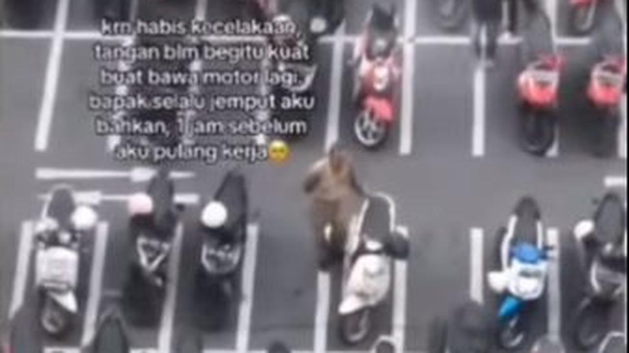 Rupanya ada seorang pria paruh baya berdiri di sebelah motor berwarna putih. Pria tersebut berdiri sendiri tanpa ada kawan bicara. Ia hanya memegangi jok belakang motor sesekali sambil melihat sekitar.