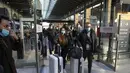 Penumpang yang tiba dari London dengan kereta Eurostar, mengenakan masker untuk melindungi dari COVID-19 keluar dari gerbang kedatangan di stasiun kereta Gare du Nord, Paris, Jumat (14/1/2022). Prancis telah mencabutnya Larangan COVID terhadap turis Inggris mulai (14/1). (AP Photo/Michel Euler)