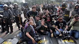 Sejumlah pewarta foto sibuk ber-selfie ria dengan latar belakang petugas Kepolisan, Jakarta, Kamis (21/8/14).(Liputan6.com/Miftahul Hayat)