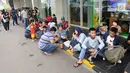 Ratusan calon pembeli duduk saat antre di depan Emporium Pluit Mall, Jakarta. Minggu (21/1). Mereka antre sejak mal belum dibuka untuk mendapatkan penawaran produk Xiaomi. (Liputan6.com/Fery Pradolo)