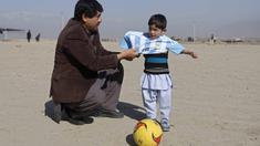 Bocah 5 tahun, Murtaza Ahmadi, asal Afghanistan menerima jersey  asli Lionel Messi lengkap dengan tanda tangan, sebelumnya bocah ini mengenakan jersey plastik nomor 10 dengan tulisan Lionel Messi. (REUTERS/Omar Sobhani)