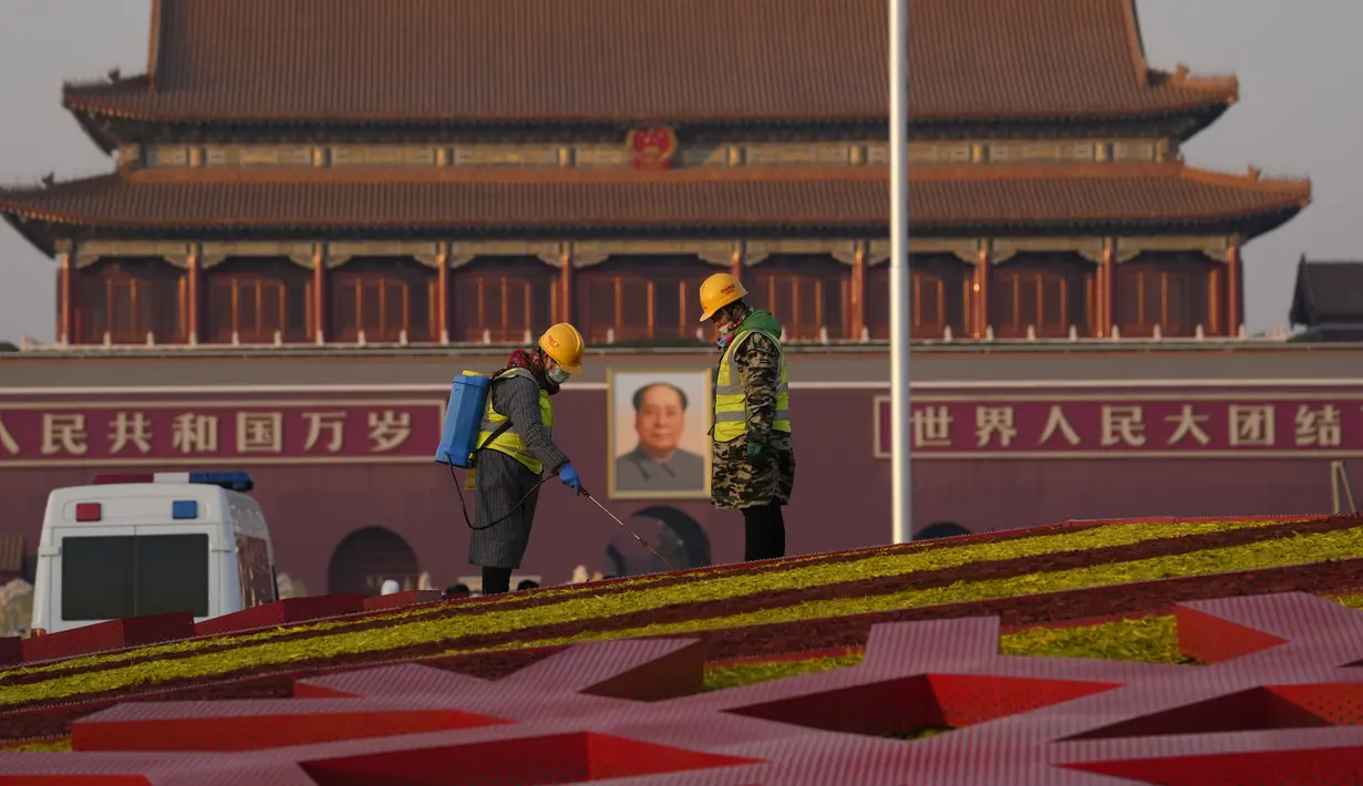 Pekerja melakukan sentuhan akhir pada tampilan Olimpiade Musim Dingin Beijing, dekat potret Mao Zedong di Gerbang Tiananmen di Beijing, China (18/1/2022). China telah mengunci sebagian distrik Haidian Beijing menyusul deteksi tiga kasus COVID-19. (AP Photo/Ng Han Guan)